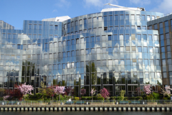 Modern office building with a mirrored glass facade and solar protection films for efficient heat protection.