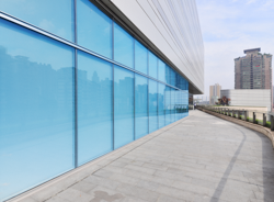 Modern glass facade with bluish sun protection film for heat insulation and privacy.
